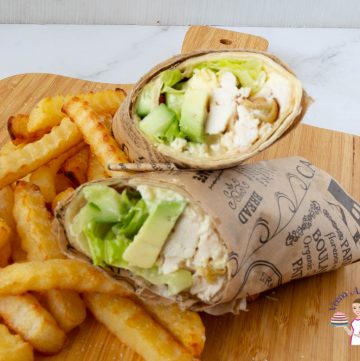 A chicken wrap on a wooden board