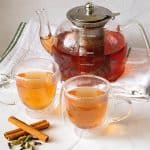 Two cups of spiced ginger tea with a kettle.