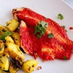 A white plate with tandoori fish.