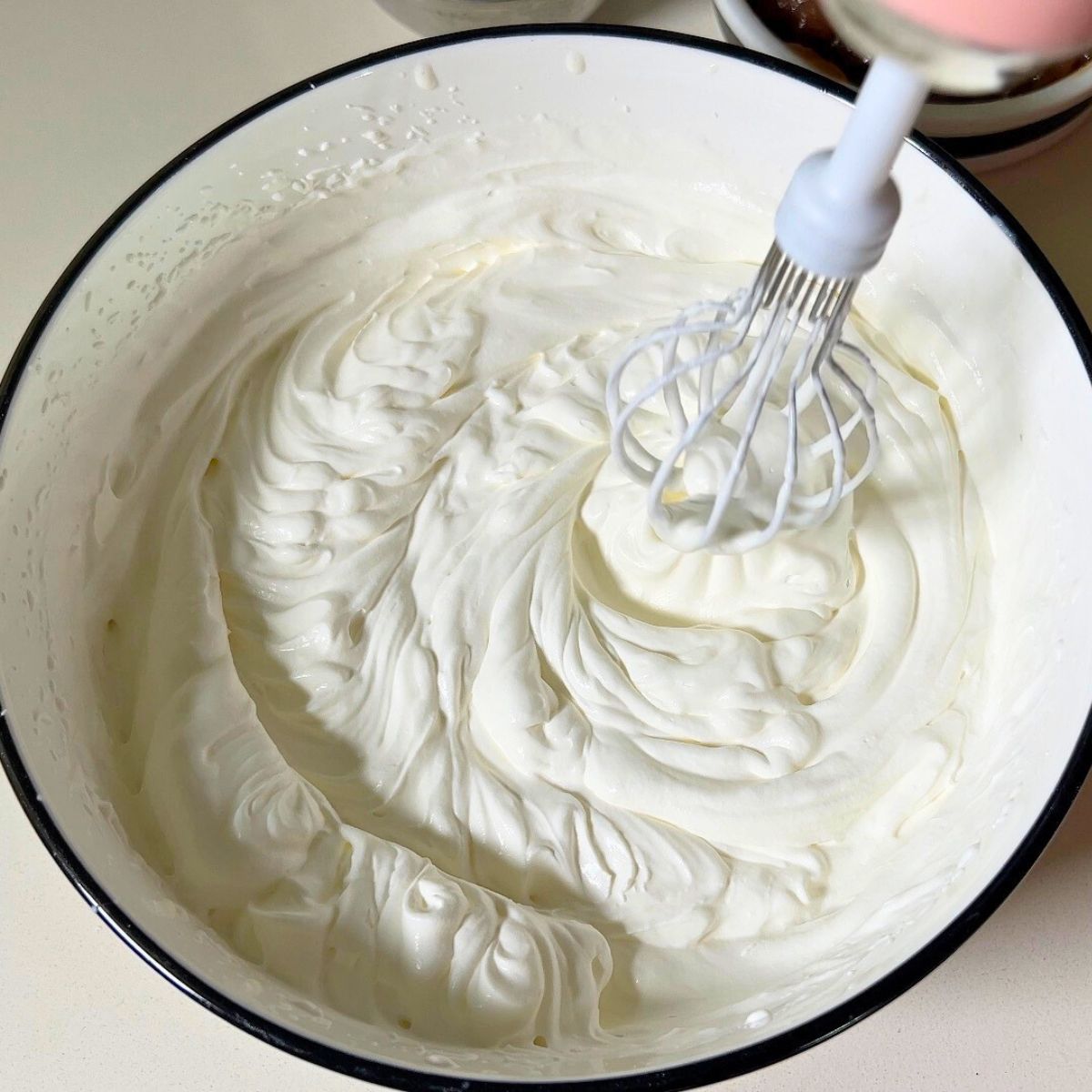 Whipping mousse in a white bowl.