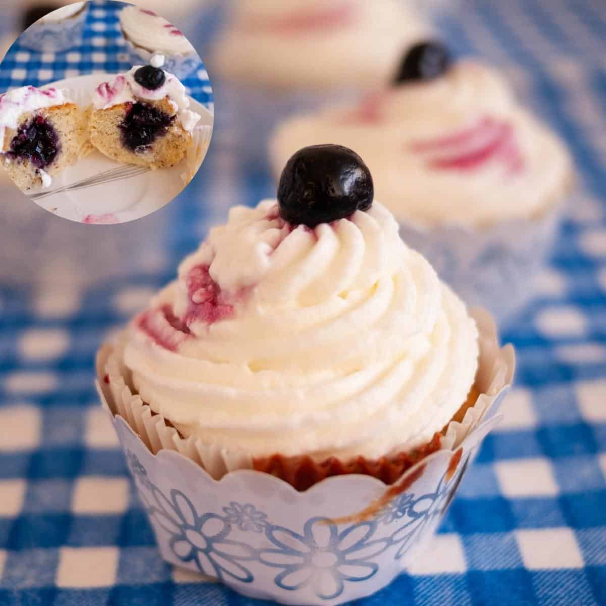 A frosted lemon cupcake with blueberry filling and cream cheese frosting.