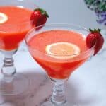 A glass with cocktail lemon slices and strawberry.