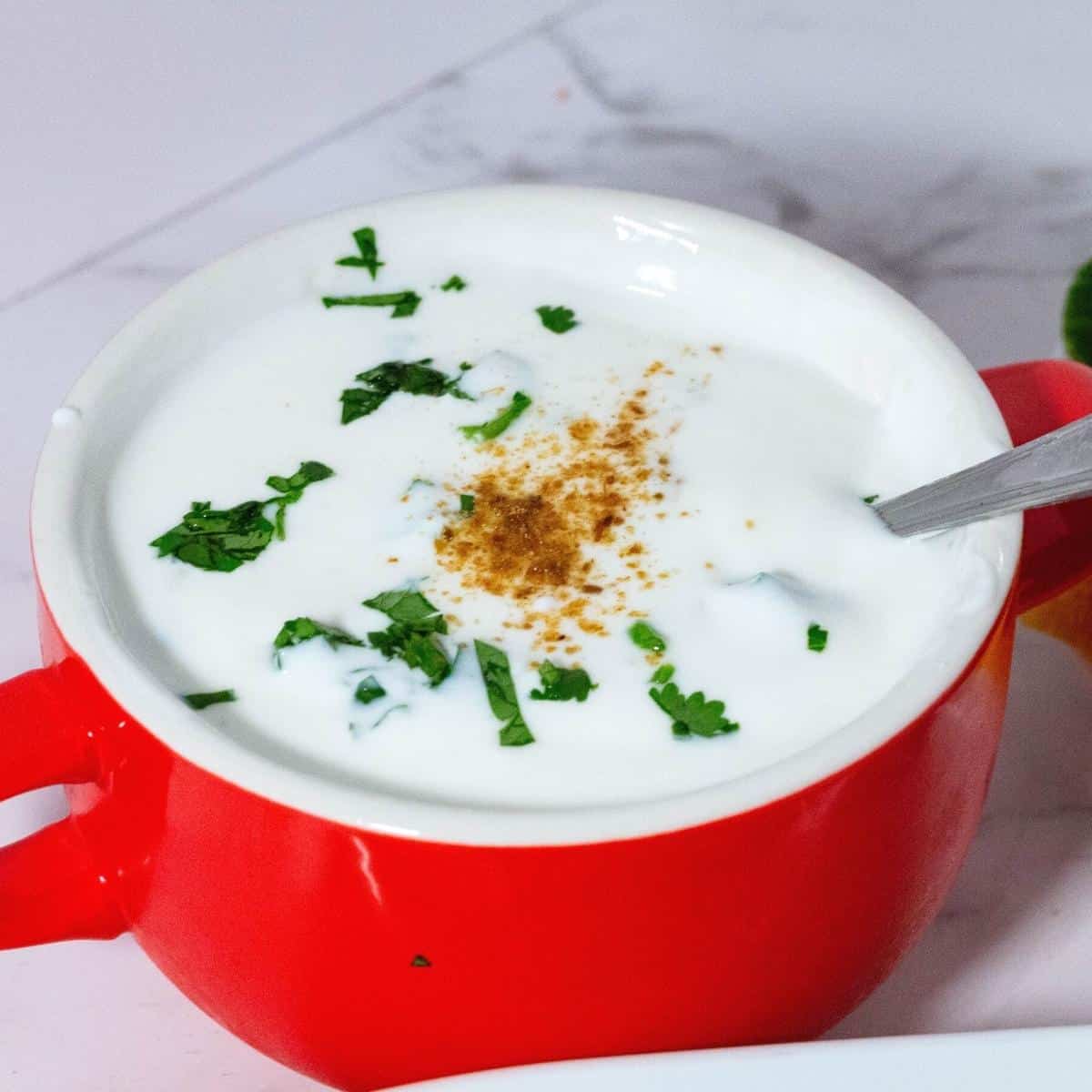 Greek yogurt raita in a bowl for biryani.