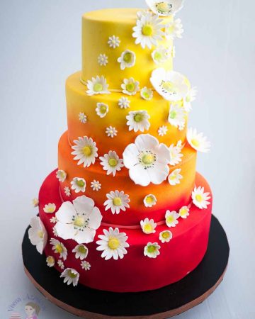 A wedding cake with sugar daisies.