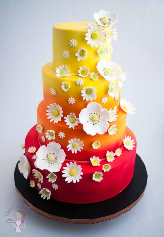 A cake decorated with gum paste daisies.