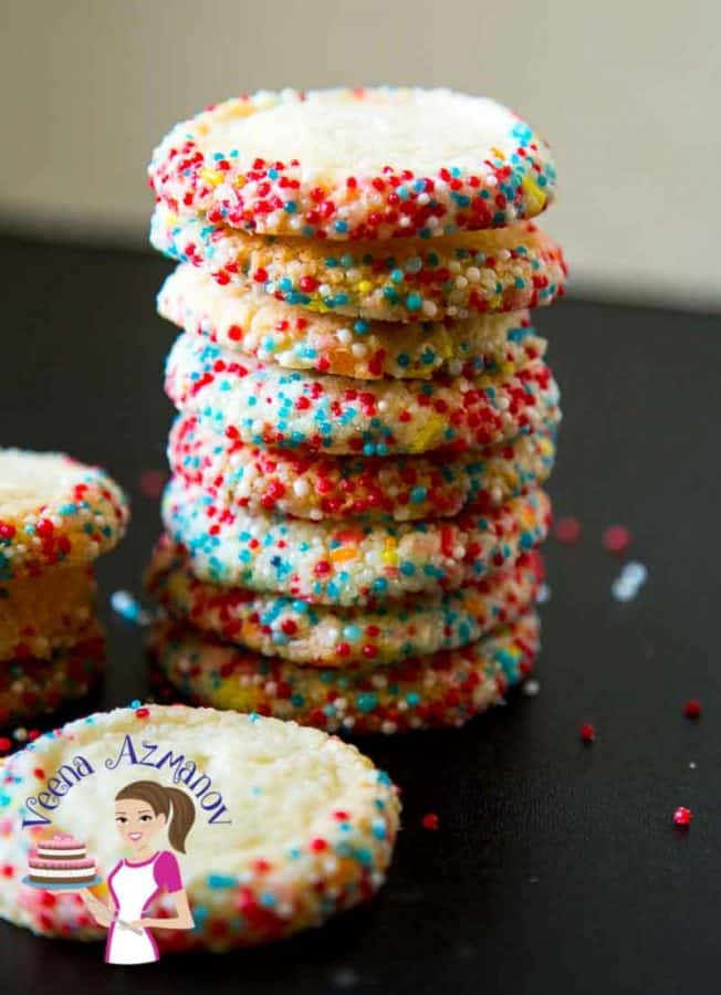A stack of sprinkle cookies on a table.