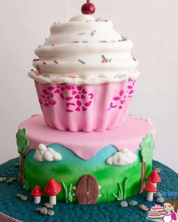 A birthday cake designed like a big cupcake with white frosting.