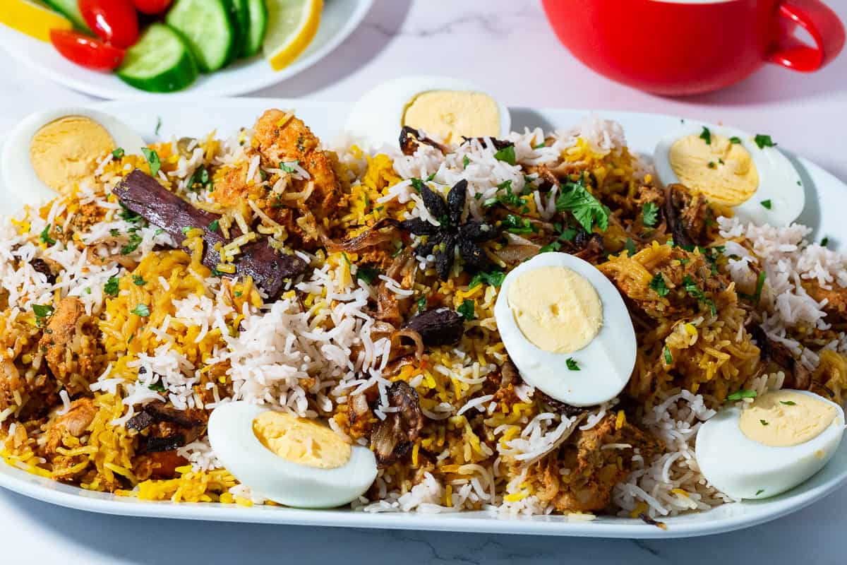A platter with chicken biryani and boiled eggs.