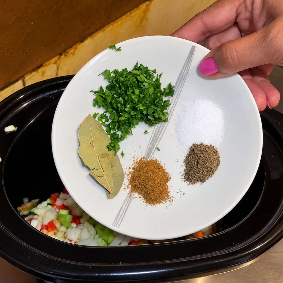 Adding spices to the slow cooker.