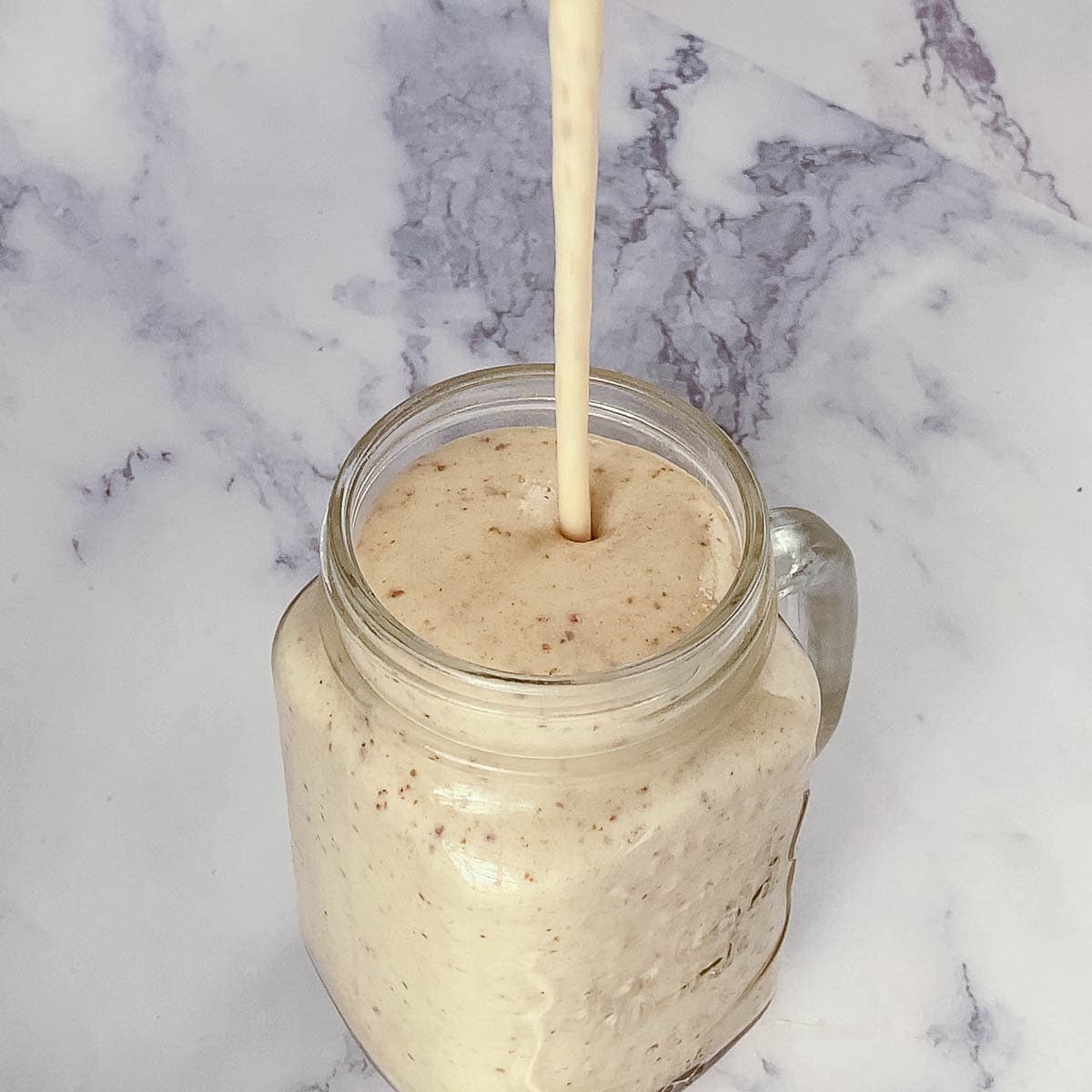 Pouring smoothie in a jar.