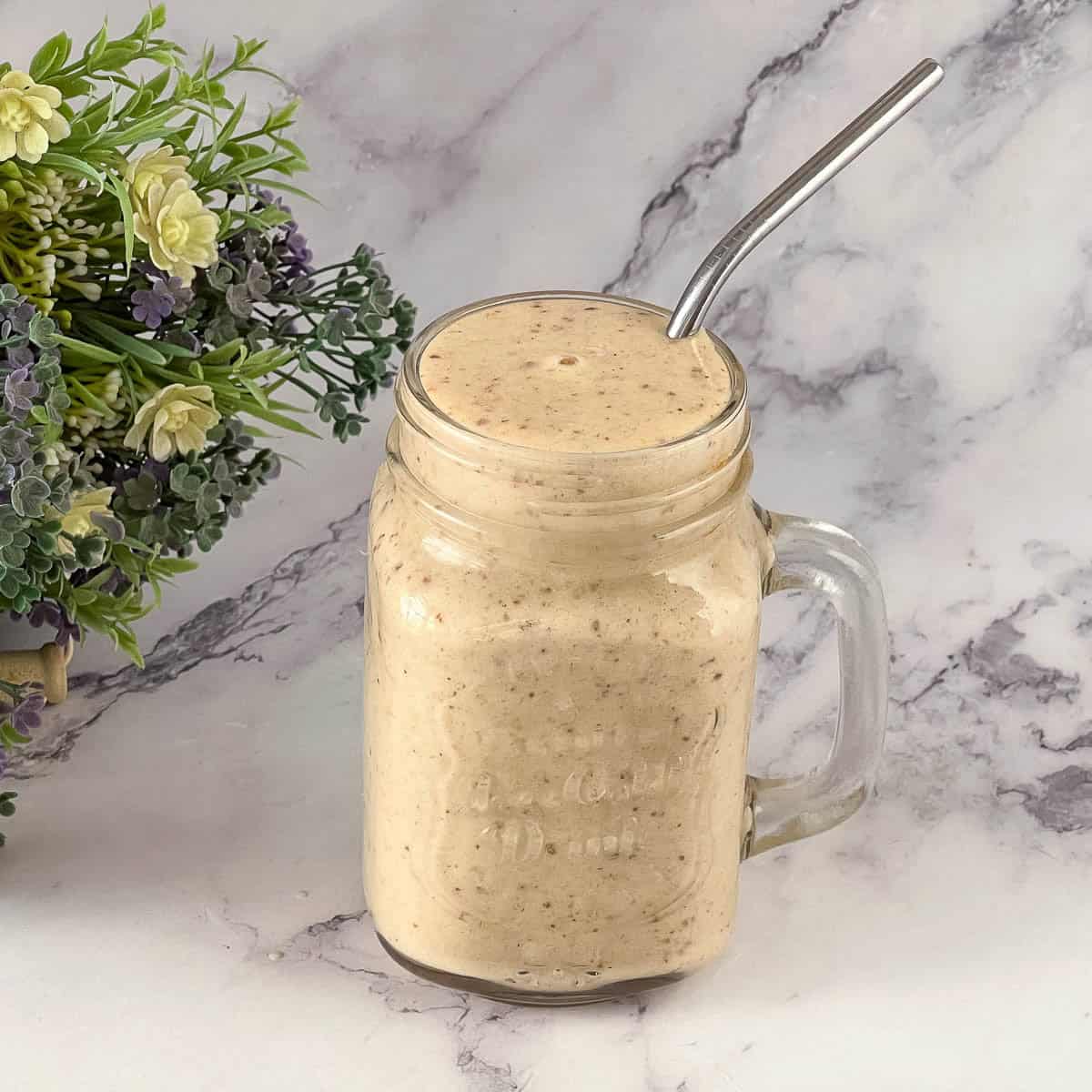 A glass with banana and dates smoothie.