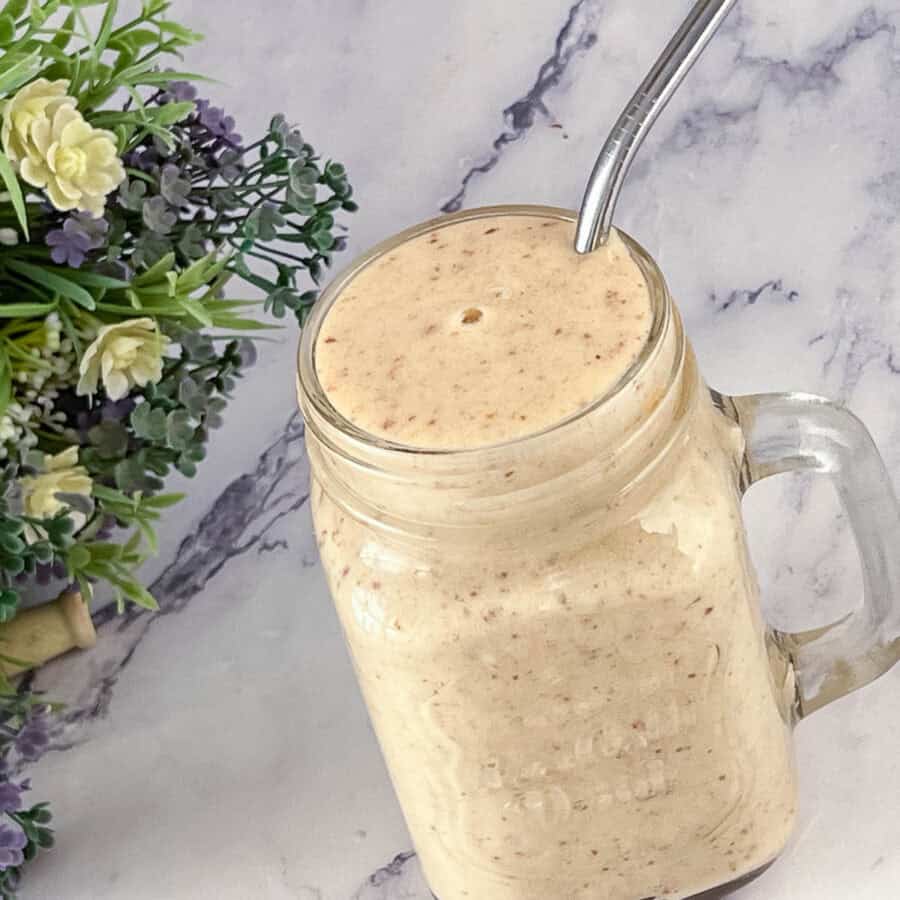 A banana and dates smoothie in a glass jar.