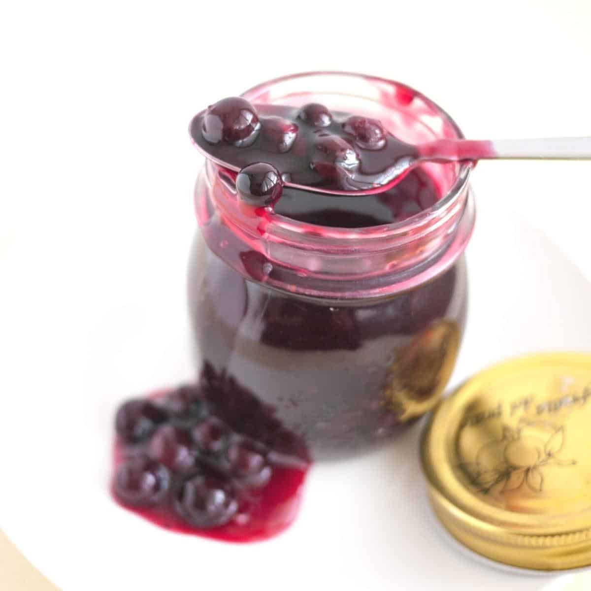 A mason jar with blueberry fruit filling.