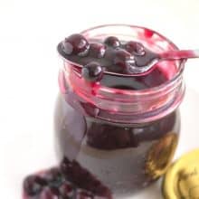 A mason jar with blueberry fruit filling.