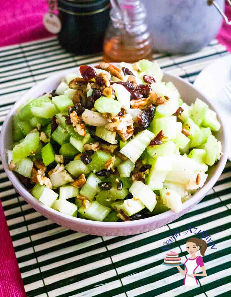 A bowl of celery salad with pecans and cranberries.