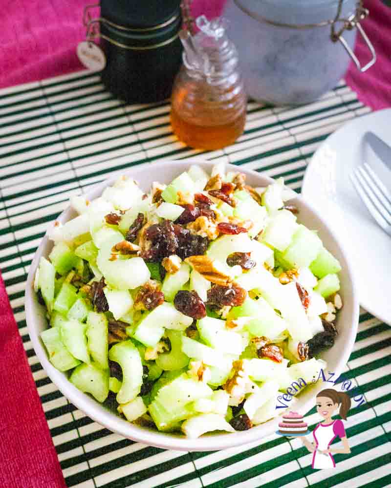 A bowl of celery salad with pecans and cranberries.