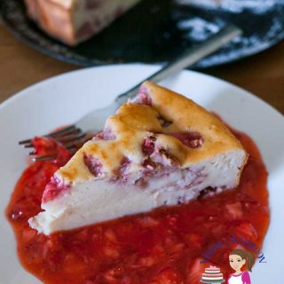A piece of strawberry cheesecake on a plate with strawberry sauce and a fork.