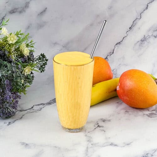 Mango smoothie in a tall glass.