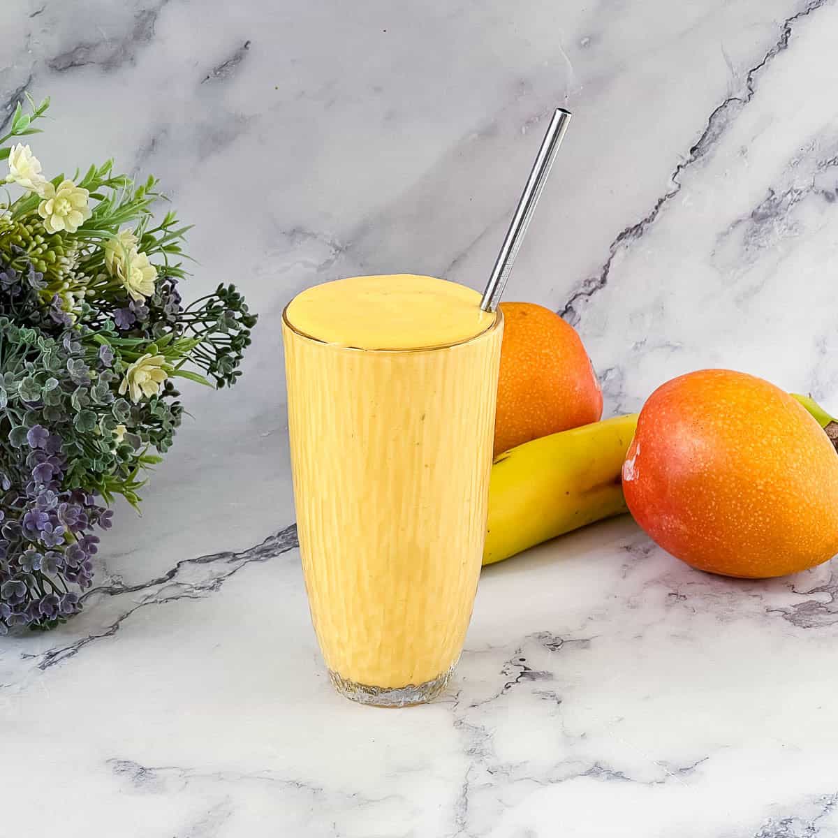 Mango smoothie in a tall glass.