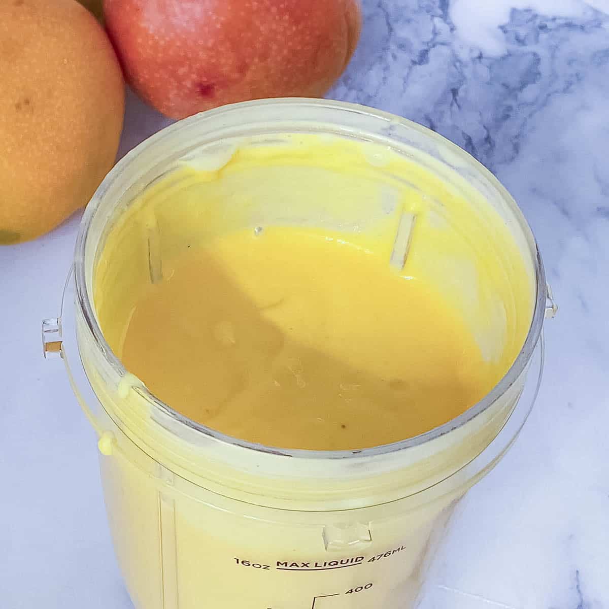 A blender with fresh mango smoothie.