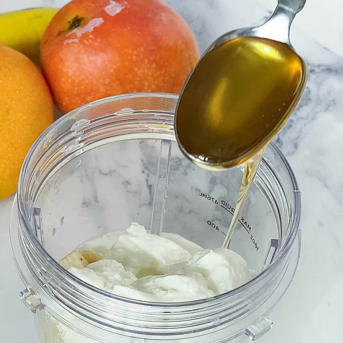 Adding honey to the blender.