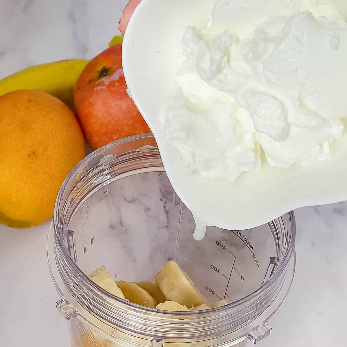Adding Greek yogurt to the blender.