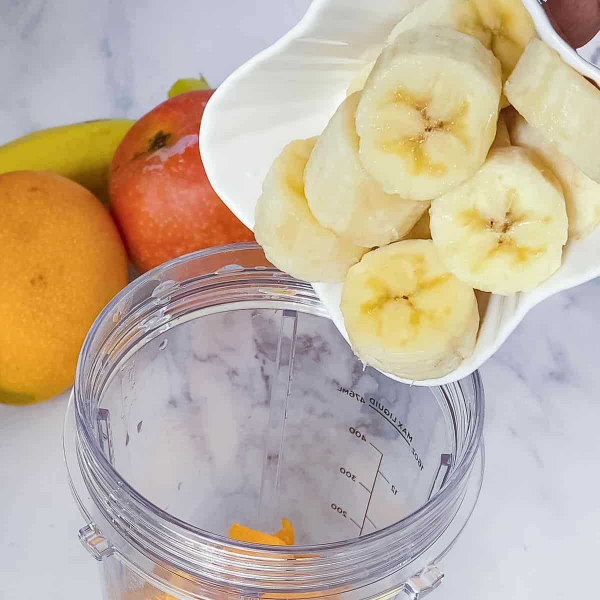 Adding banana to the blender.