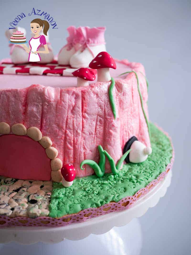 A cake decorated as a pink tree stump.