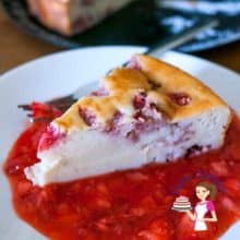 A slice of ricotta cheesecake with strawberry sauce.
