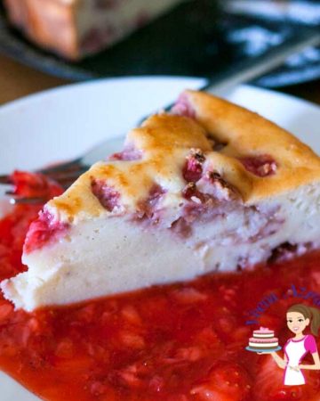 A slice of ricotta cheesecake with strawberry sauce.