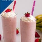 Two glasses with milkshake topped with strawberry