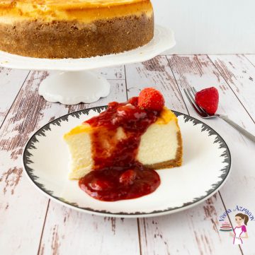 A slice of Cheesecake with strawberry topping on a plate.
