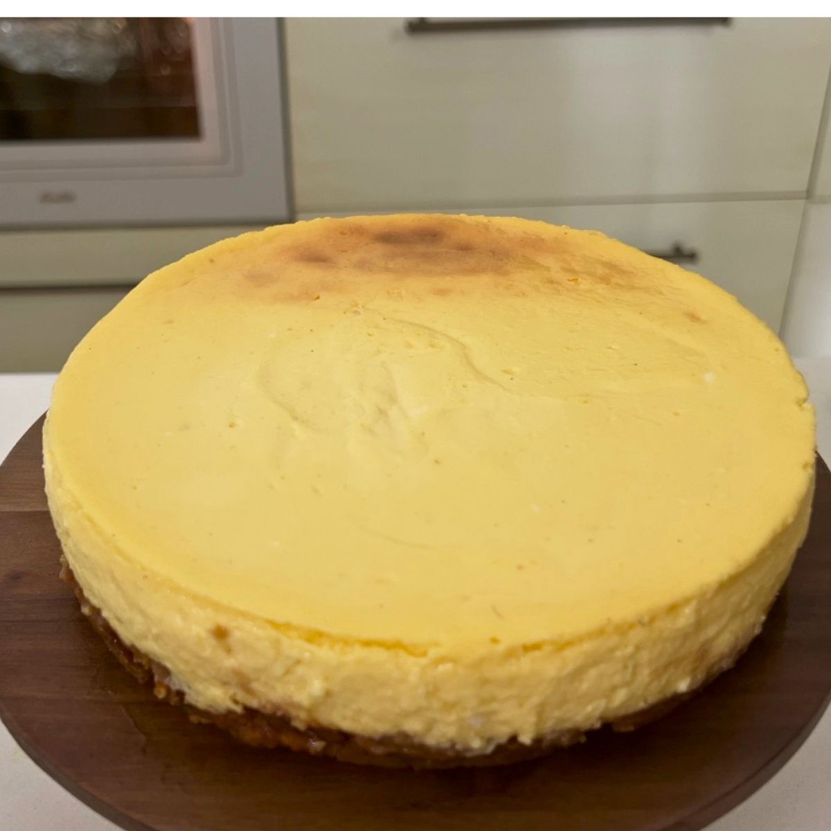 A mango cheesecake on the cake stand for frosting.