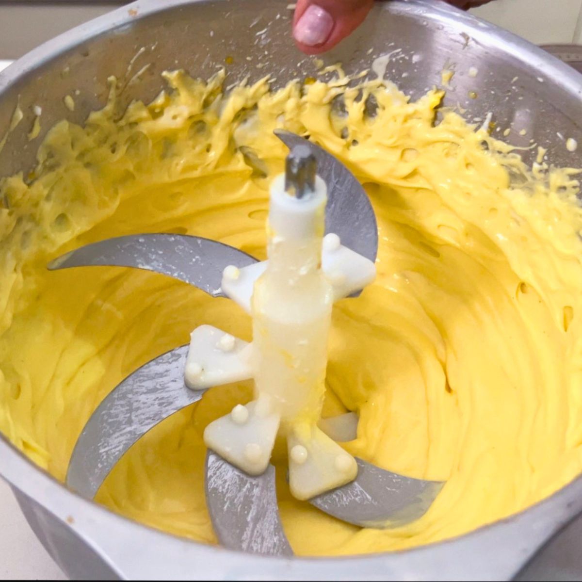 A food processor with mango cheesecake batter.