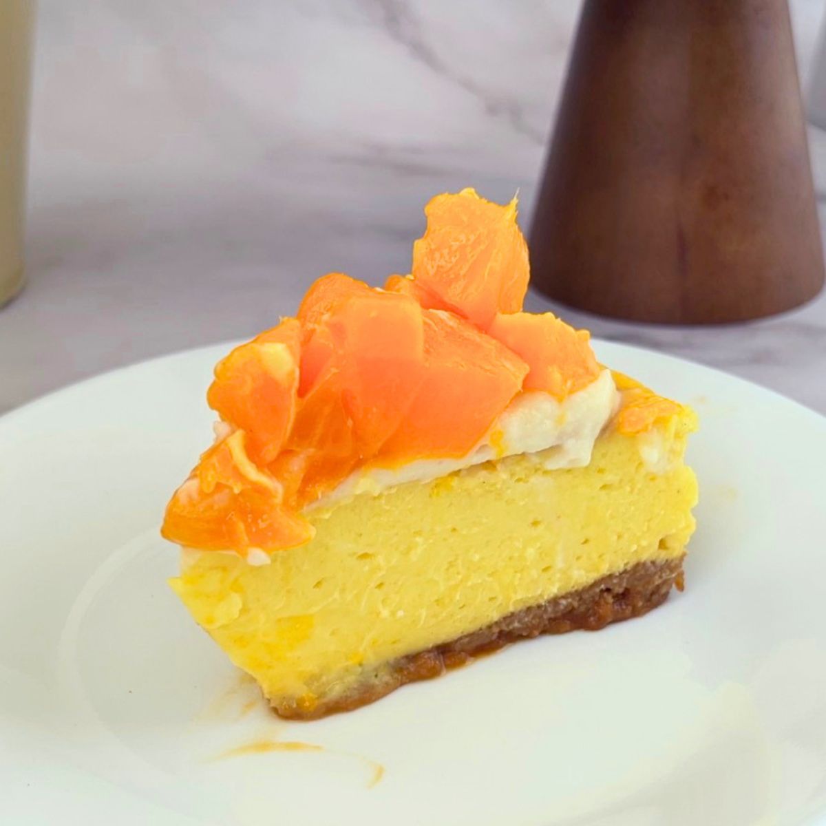 A slice of mango cheesecake on the plate.
