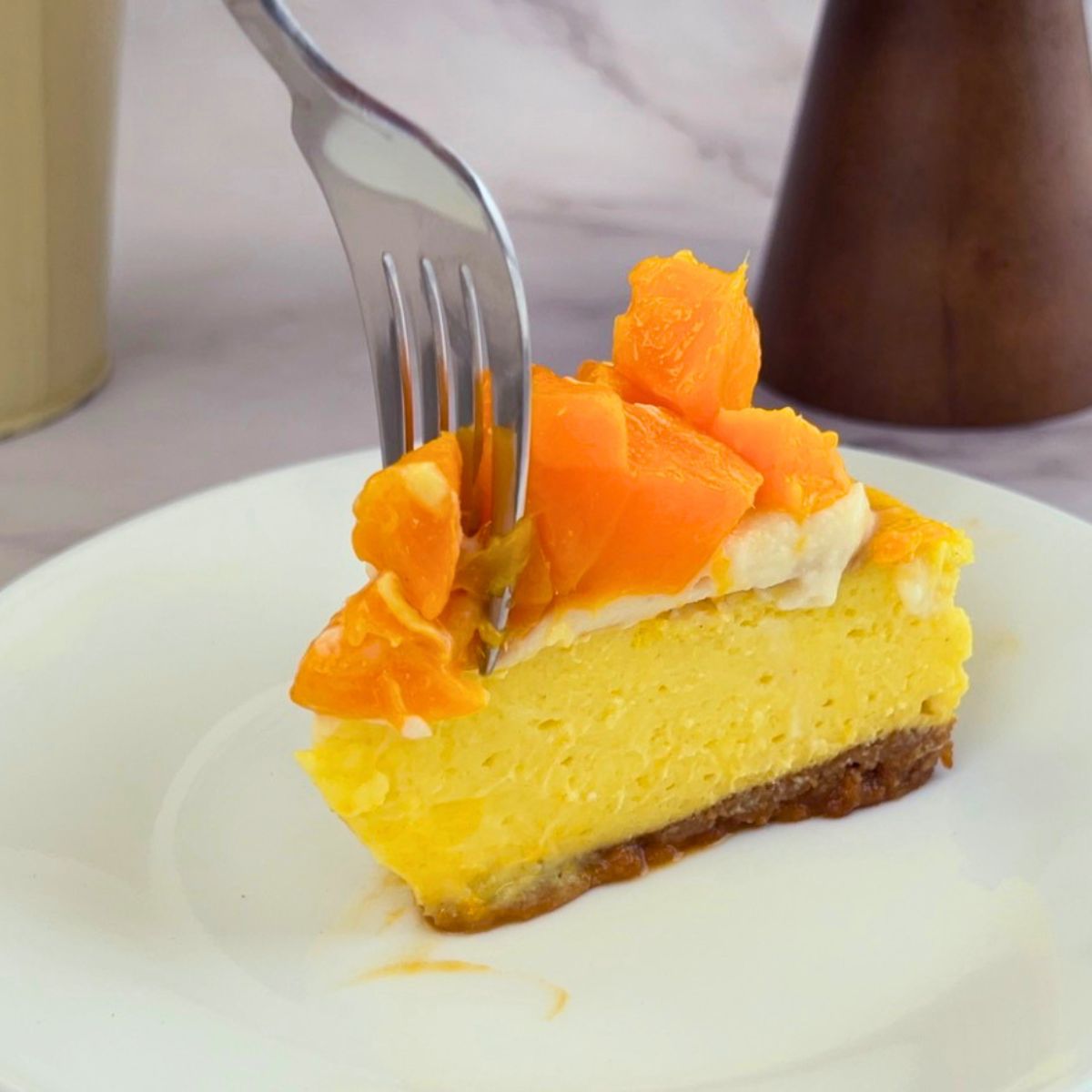 A plate with mango cheesecake slice.