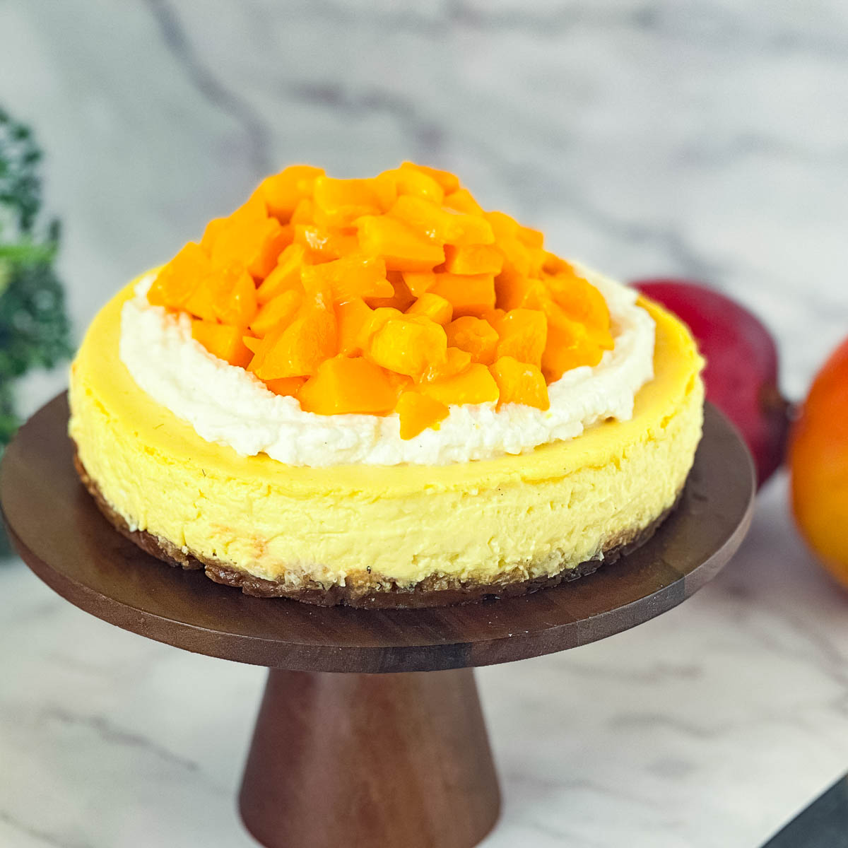 A cake stand with mango cheesecake.