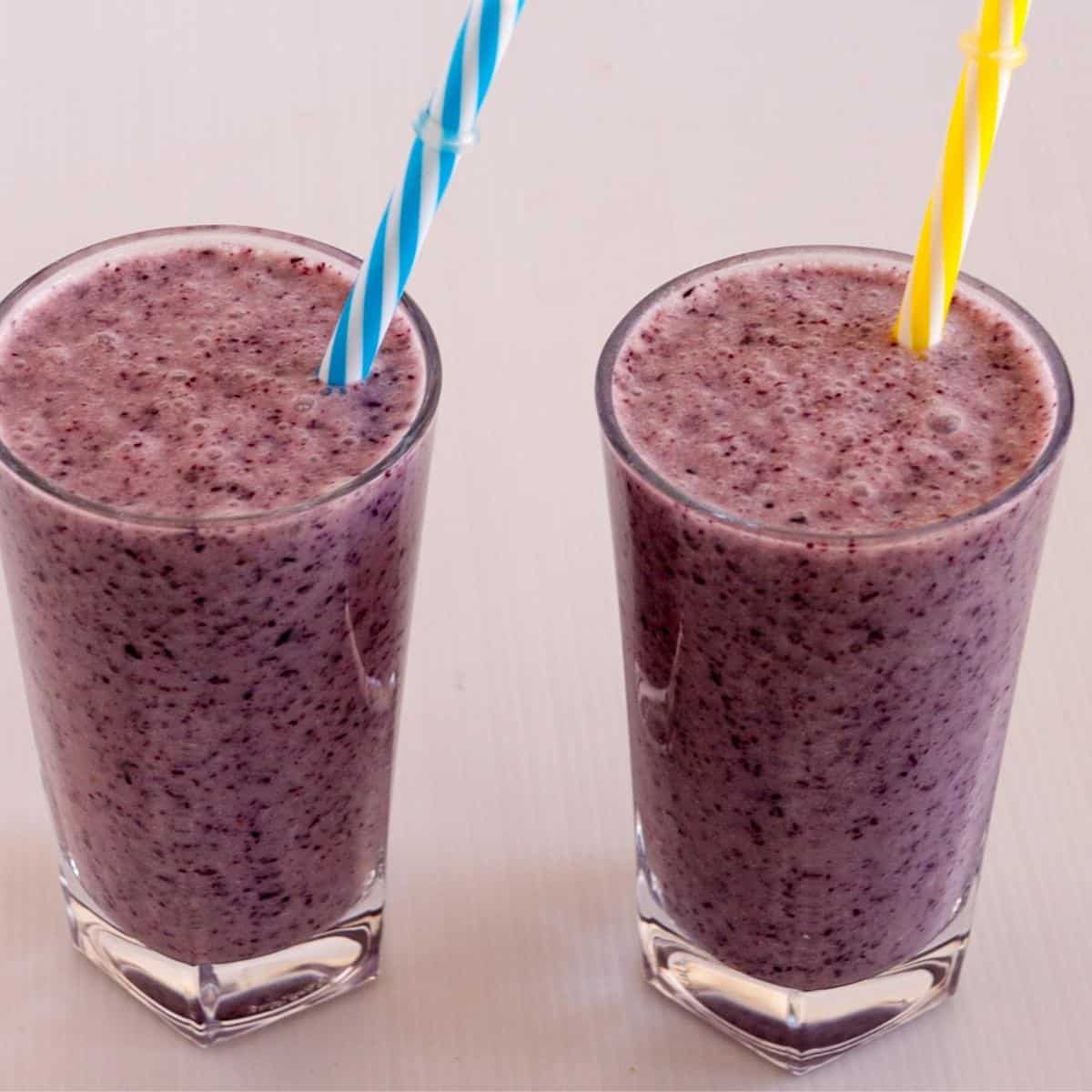 Two glasses of blueberry banana smoothie.