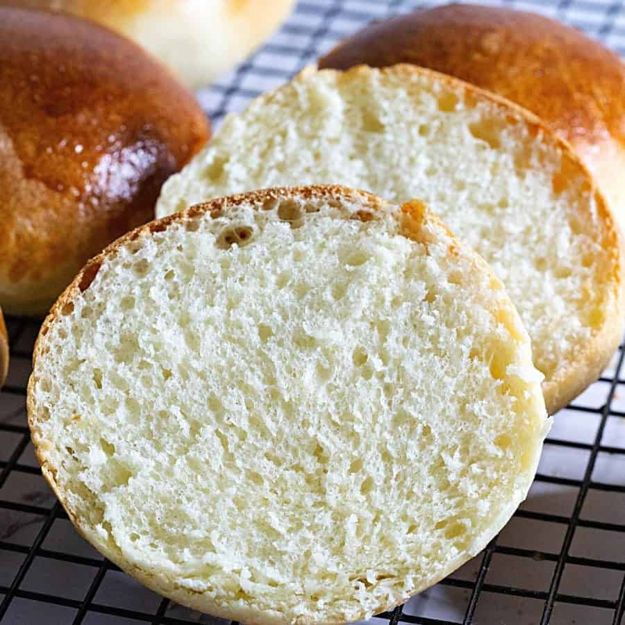 A sliced brioche bun in hand.