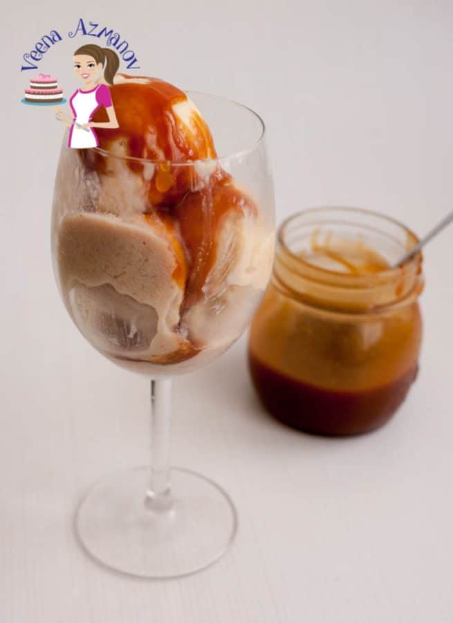 Two scoops of banana ice cream in a wine glass topped with caramel sauce