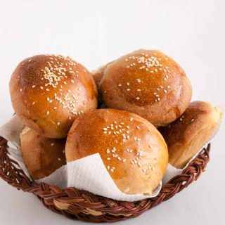 Whole wheat hamburger buns in a basket.