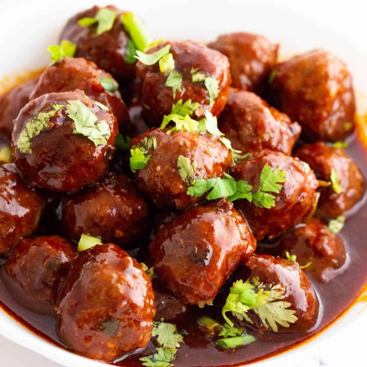 A bowl with meatballs in sweet and sour sauce.