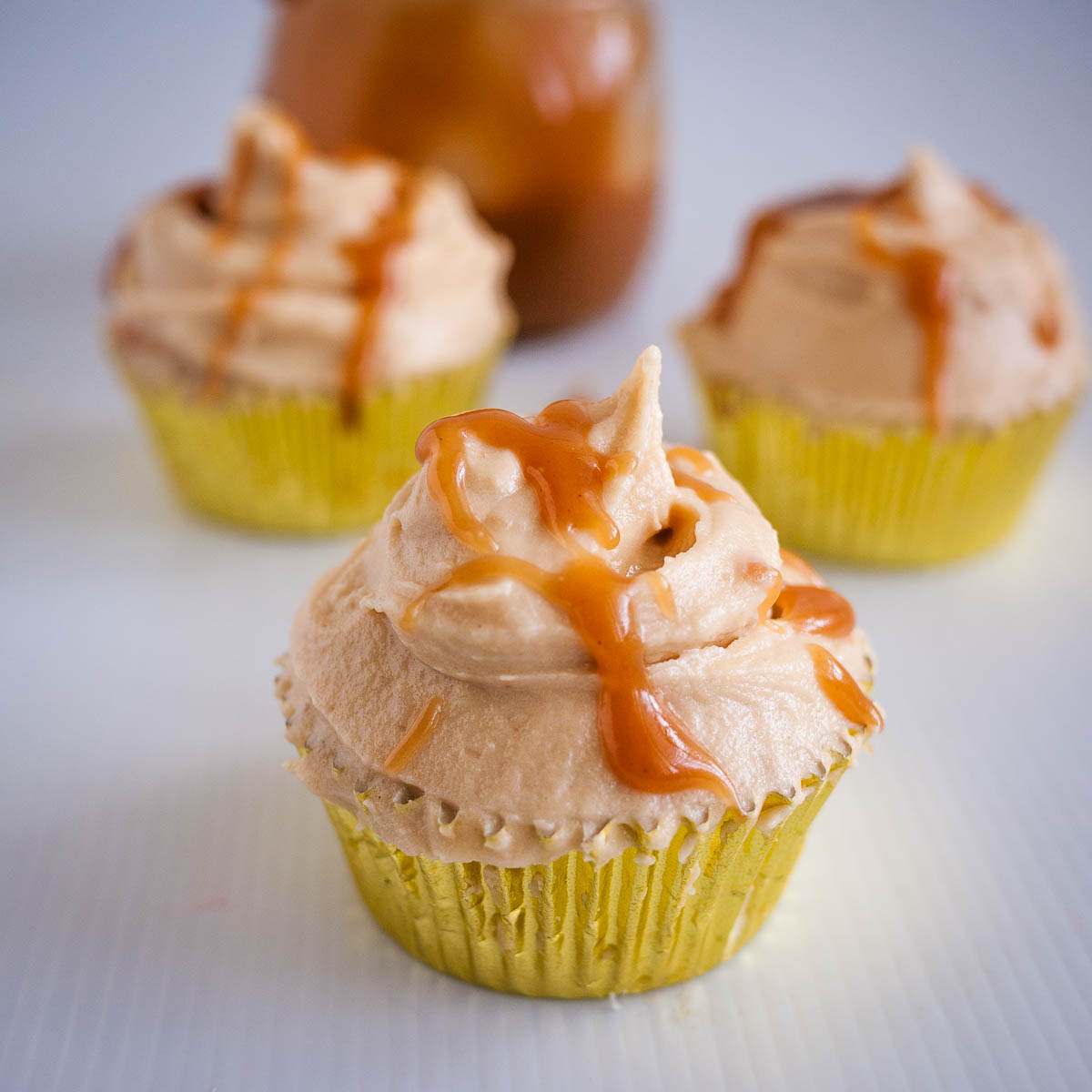Butterscotch frosted cupcakes on the table.