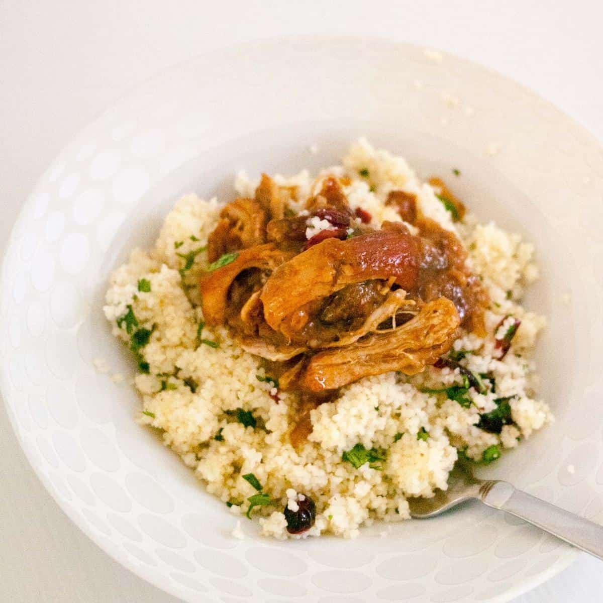 A bowl with slow-cooked chicken and couscous.