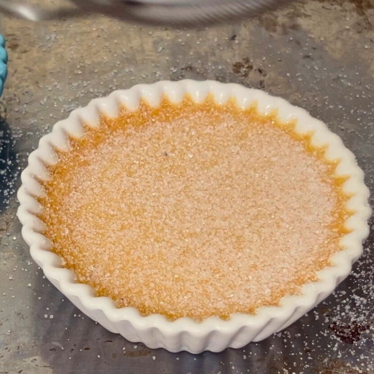 A creme brulee ramekin with castor sugar.