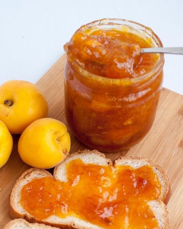 Slice of bread and mason jar with apricot jam.