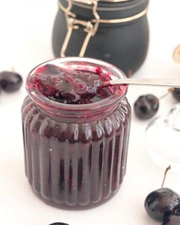 A mason jar with cherry fruit filling.