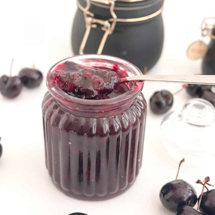 A mason jar with cherry fruit filling.