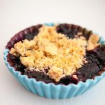 A ramekin with blueberry fruit crumble.