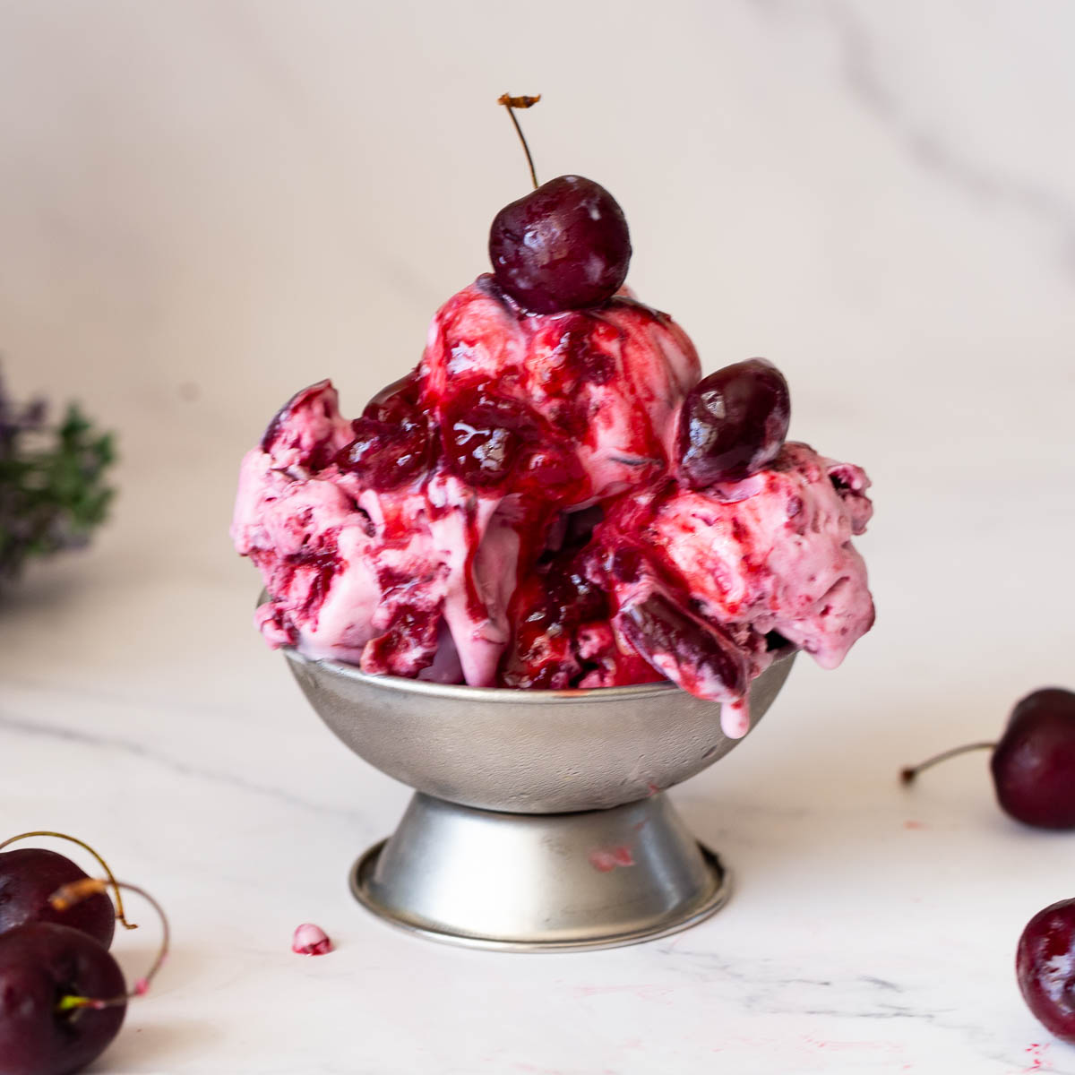 An Ice cream bowl with cherry ice cream.